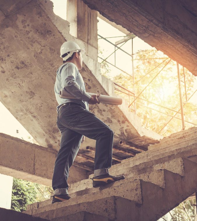 Builder climbing stairs of construction site