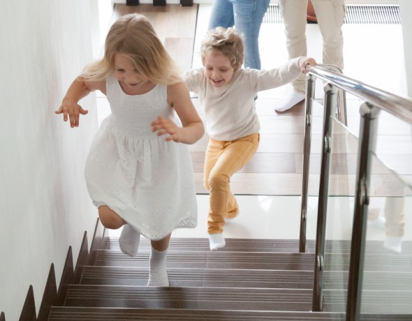 Children running up glass stairs